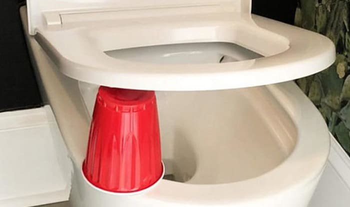 why put a red cup under toilet seat at night